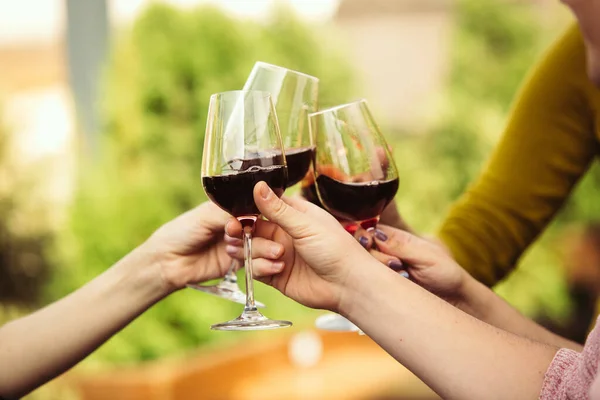 Gente tintineando vasos con vino en la terraza de verano de la cafetería o restaurante. Primer plano, estilo de vida . — Foto de Stock