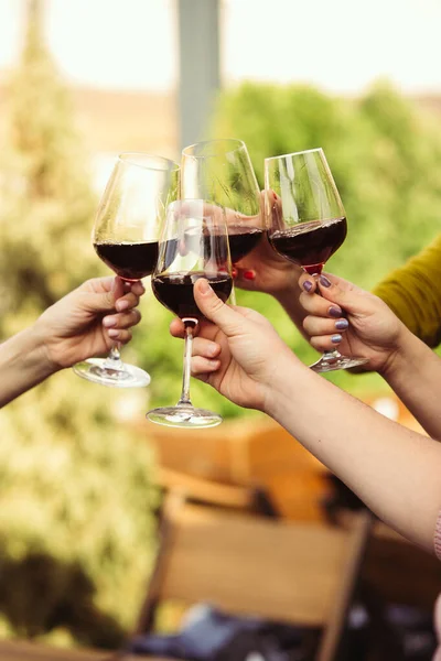 Gente tintineando vasos con vino en la terraza de verano de la cafetería o restaurante. Primer plano, estilo de vida . —  Fotos de Stock