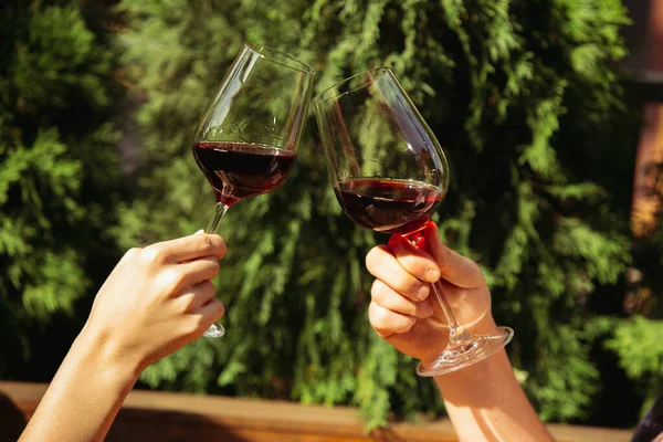 Menschen, die auf der Sommerterrasse eines Cafés oder Restaurants Gläser mit Wein klappern. Nahaufnahme, Lebensstil. — Stockfoto