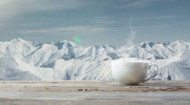 Tek çay ya da kahve fincanı ve arka planda dağların manzarası