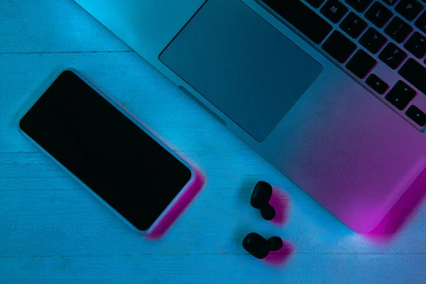Vista superior do conjunto de gadgets na luz de néon roxo — Fotografia de Stock