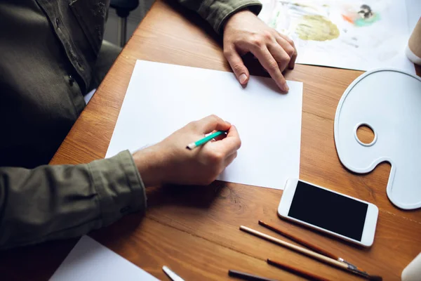 Primer plano del dibujo del hombre con pinturas y lápices en casa. Educación remota, ocupación creativa, terapia de arte — Foto de Stock