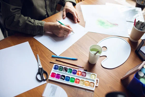 Primer plano del dibujo del hombre con pinturas y lápices en casa. Educación remota, ocupación creativa, terapia de arte — Foto de Stock