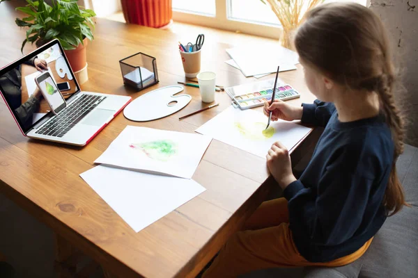 Fille dessin avec des peintures et des crayons à la maison, regarder les enseignants tutoriel sur ordinateur portable. Numérisation, enseignement à distance — Photo