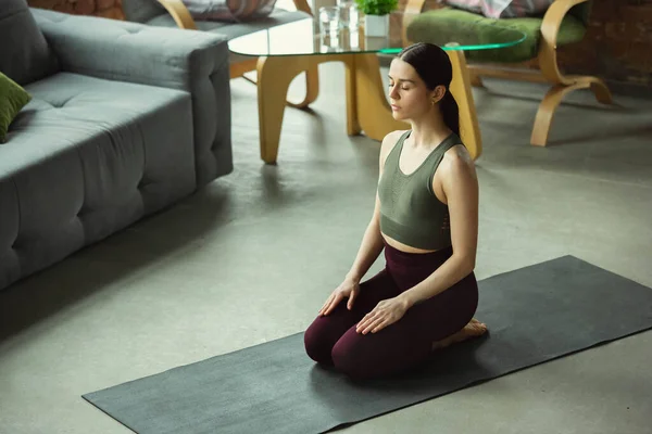 Sportieve jonge vrouw oefenen yoga thuis — Stockfoto