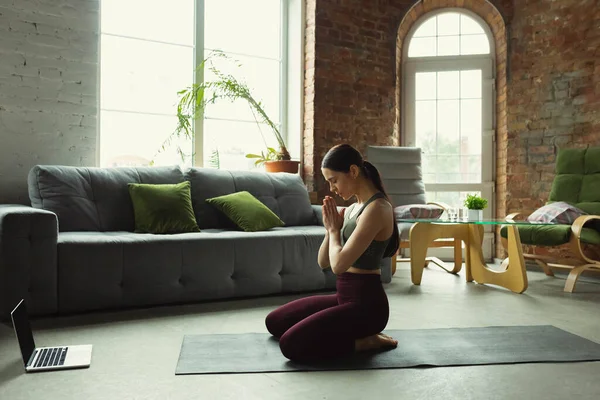 Sportos fiatal nő vesz jóga órák online és a gyakorlat otthon — Stock Fotó