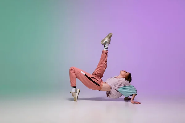 Chica bailando hip-hop en ropa elegante sobre fondo degradado en el salón de baile en luz de neón . — Foto de Stock