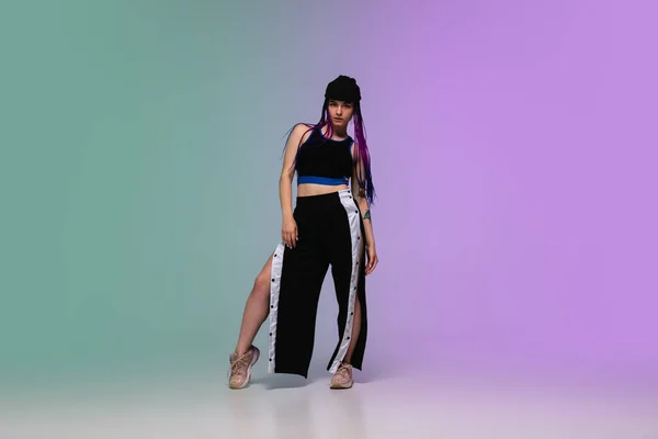 Lány tánc hip-hop elegáns ruhák gradiens háttér táncterem neon fény. — Stock Fotó