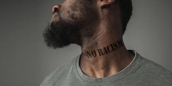 인종 차별에 지친 흑인의 초상을 클로즈업하는 것은 그 의 목에 구호를 문신했다. — 스톡 사진