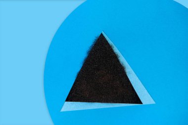 Afro-Amerikalı bir adamın saçı mavi arka plandaki üçgenden gizlice bakıyor.