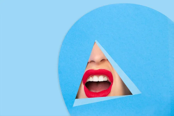 Labios rojos femeninos asomándose a través del triángulo en fondo azul — Foto de Stock