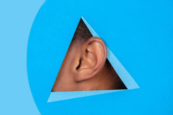 Fül afro-amerikai férfi kukucskál keresztül háromszög kék háttér — Stock Fotó