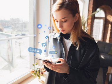 Sosyal medyayı bağlayan ve paylaşan bir kız. Modern UI simgeleri, iletişim, aygıtlar