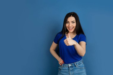 Mavi stüdyo arka planında izole edilmiş beyaz kadın portresi.