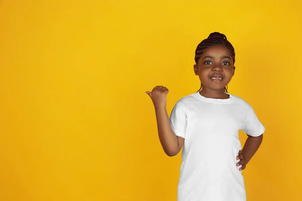 Little african-american girls portrait isolated on yellow studio background — Stok Foto