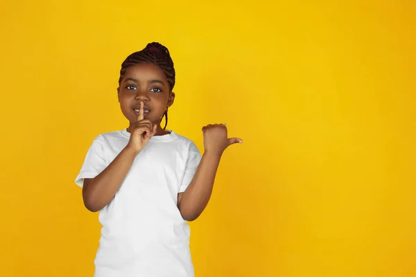 Little african-american girls portrait isolated on yellow studio background — Stok Foto