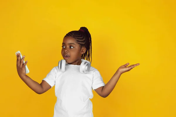 Little african-american girls portrait isolated on yellow studio background — Stok Foto