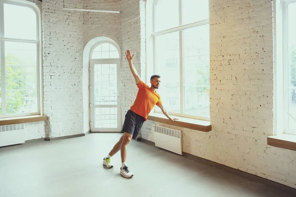 Junge kaukasische Mann Training zu Hause während der Quarantäne von Coronavirus Ausbruch, Übungen der Fitness, Aerobic. Während der Isolierung sportlich bleiben. — Stockfoto