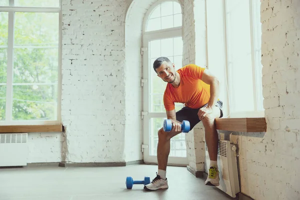 Junge kaukasische Mann Training zu Hause während der Quarantäne von Coronavirus Ausbruch, Übungen der Fitness, Aerobic. Während der Isolierung sportlich bleiben. — Stockfoto