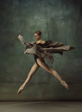 Karanlık stüdyo geçmişinde zarif genç bir balerin.