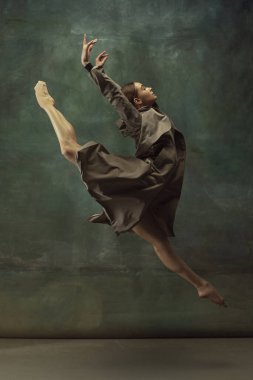 Karanlık stüdyo geçmişinde zarif genç bir balerin.