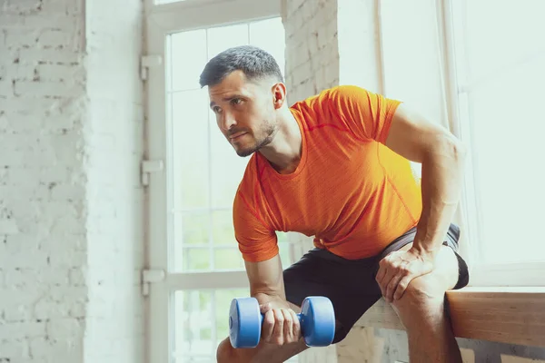 Junge kaukasische Mann Training zu Hause während der Quarantäne von Coronavirus Ausbruch, Übungen der Fitness, Aerobic. Während der Isolierung sportlich bleiben. — Stockfoto