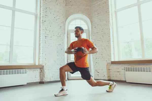 Junge kaukasische Mann Training zu Hause während der Quarantäne von Coronavirus Ausbruch, Übungen der Fitness, Aerobic. Während der Isolierung sportlich bleiben. — Stockfoto