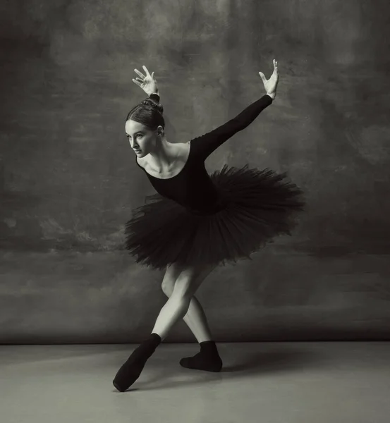 Mladý půvabný jemný balerína na tmavém pozadí studia — Stock fotografie