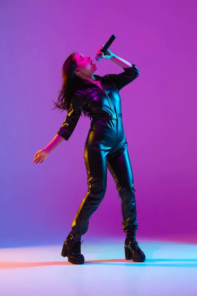 Portrait de chanteuse caucasienne isolé sur fond de studio violet au néon — Photo