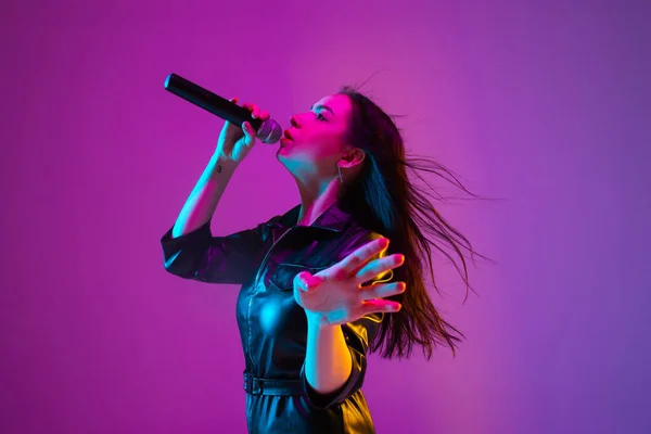 Portrait de chanteuse caucasienne isolé sur fond de studio violet au néon — Photo