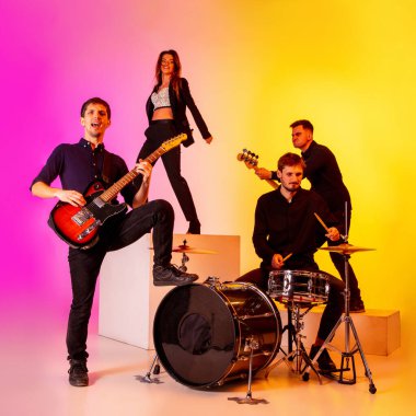 Genç Kafkasyalı müzisyenler, müzik grubu gradient stüdyo arka planında neon ışığı altında performans sergiliyor.