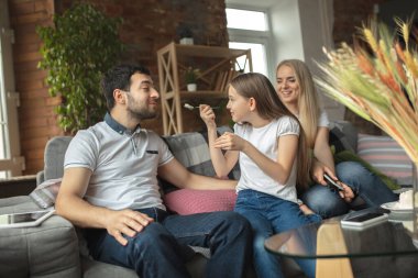 Anne, baba ve kız evde eğleniyor, rahat ve rahat bir konsept.