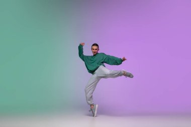 Hip-hop dansı yapan bir çocuk. Şık kıyafetler içinde, arka planda. Dans salonunda, neon ışıkta..