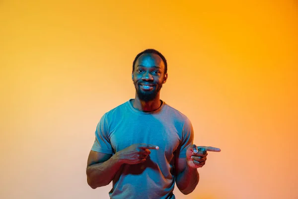 Africano-americano mans retrato isolado no gradiente laranja estúdio fundo em luz de néon — Fotografia de Stock