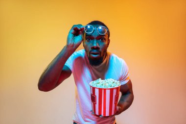 Afro-Amerikan erkek portresi, neon ışıklı arka planda izole edilmiş turuncu stüdyo.