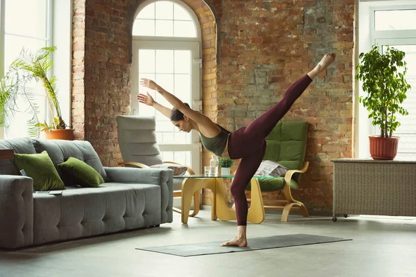 Giovane donna sportiva che pratica yoga a casa — Foto Stock