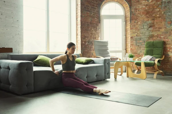 Sportieve jonge vrouw oefenen yoga thuis — Stockfoto