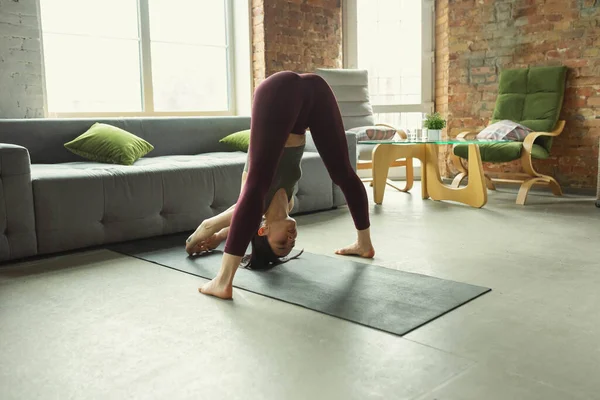 Giovane donna sportiva che pratica yoga a casa — Foto Stock