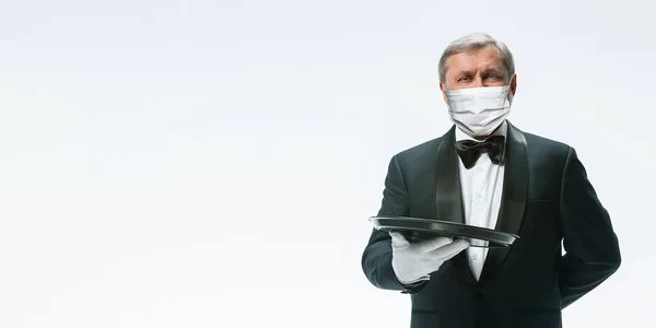 Элегантность старший официант в защитной маске на белом фоне. Флаер с копирайтом . — стоковое фото