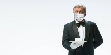 Beyaz arka planda koruyucu maskeli üst düzey garson. Kopyalama alanı olan broşür.