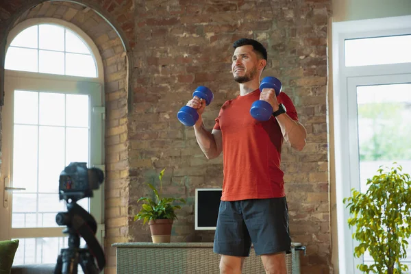 Junge kaukasische Mann Training zu Hause während der Quarantäne von Coronavirus Ausbruch, Übungen der Fitness, Aerobic. Während der Isolierung sportlich bleiben. — Stockfoto