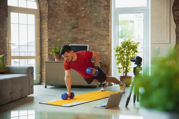 Junge kaukasische Mann Training zu Hause während der Quarantäne von Coronavirus Ausbruch, Übungen der Fitness, Aerobic. Während der Isolierung sportlich bleiben. — Stockfoto