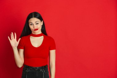 Kırmızı stüdyo arka planında tek renkli beyaz kadın portresi, duygusal ve anlamlı.