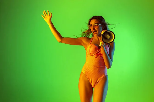 Schöne Mädchen in modischen Badeanzug isoliert auf Steigungen Studio Hintergrund in Neonlicht. Sommer, Resort, Mode und Wochenendkonzept — Stockfoto