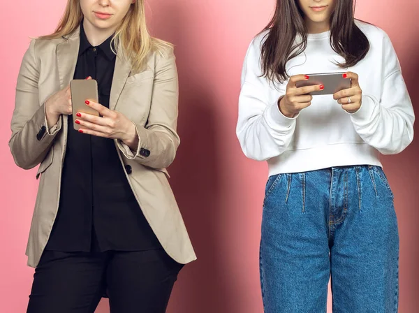 Deux filles, amies utilisant des smartphones mobiles. Addiction des adolescents aux nouvelles tendances technologiques. Gros plan. — Photo