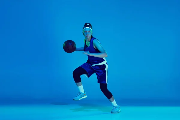 Młody biały kobieta koszykarz odizolowany na niebieski studio tło w neon światło — Zdjęcie stockowe