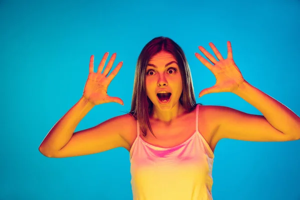 Mulheres brancas jovens retrato isolado no fundo azul em luz de néon — Fotografia de Stock