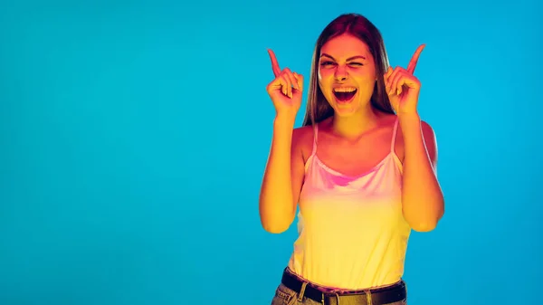 Mujeres jóvenes caucásicas retrato aislado sobre fondo azul en luz de neón — Foto de Stock