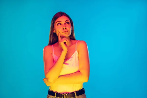 Ritratto caucasico delle giovani donne isolato su sfondo blu in luce al neon — Foto Stock