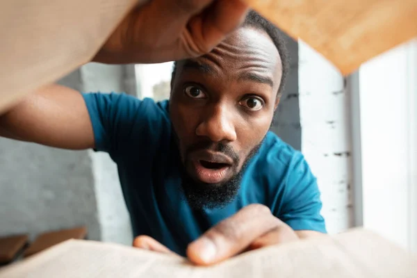 African-american man looking for job in unusual places at his home — Stock Photo, Image